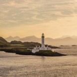 Article thumbnail: Lismore Lighthouse with dramatic sky at sunrise. Lismore lighthouse lies just off the Isle of Lismore on the tiny island of Eilean Musdile in the Firth of Lorn.